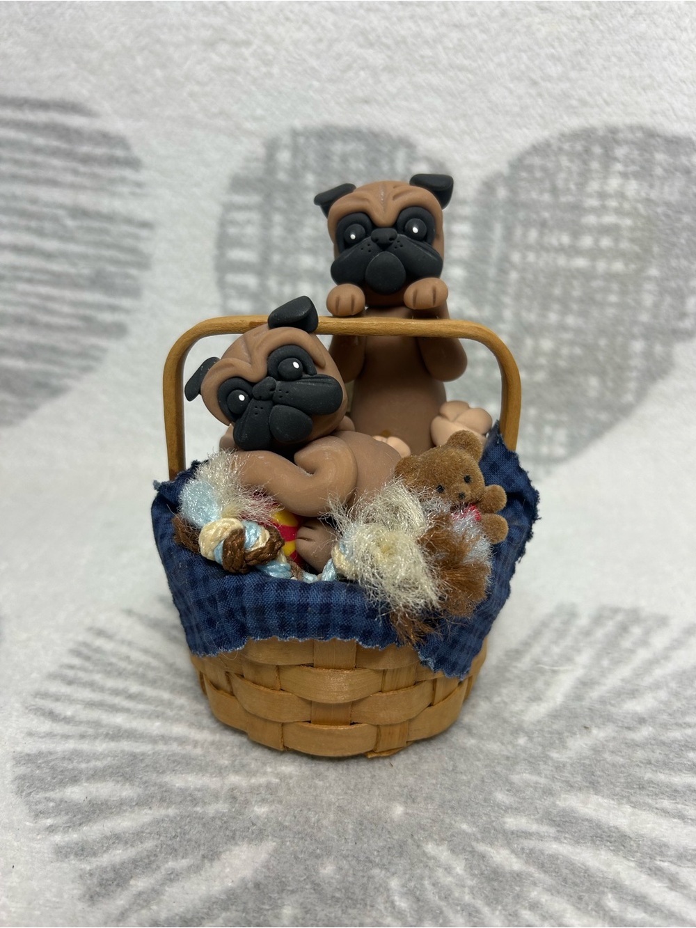 Cute pug puppies sitting inside a small woven basket working music box